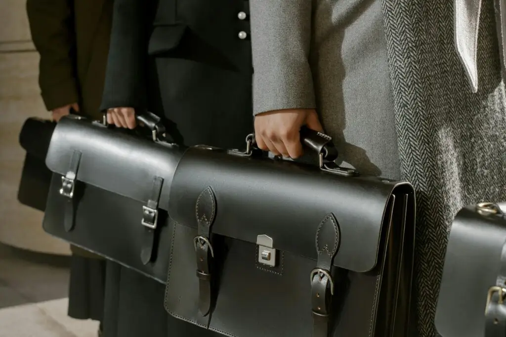 pexels-photo-6535346-6535346 - UK Direct Chauffeurs Group of adults holding sleek leather briefcases in formal business attire, emphasizing corporate professionalism.